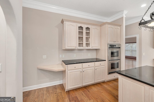 kitchen with light hardwood / wood-style floors, double oven, and ornamental molding