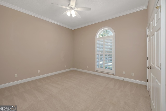 spare room featuring light carpet, crown molding, and ceiling fan