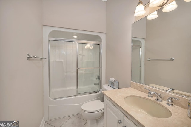 full bathroom with toilet, tile floors, large vanity, and shower / bath combination with glass door