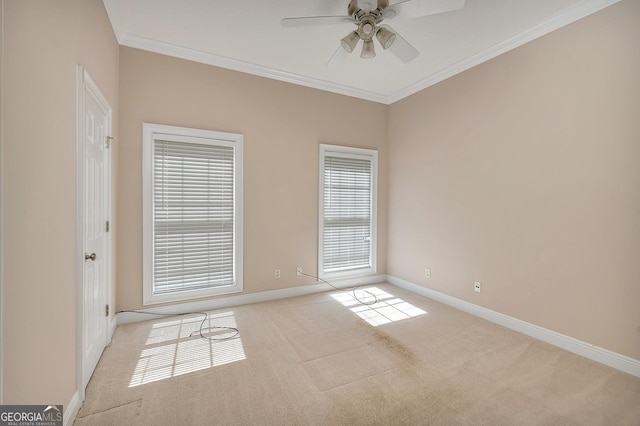 empty room featuring ceiling fan, crown molding, and light colored carpet