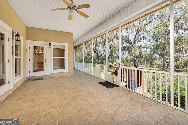 unfurnished sunroom with ceiling fan and a wealth of natural light