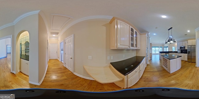 kitchen with appliances with stainless steel finishes, a kitchen island, light hardwood / wood-style floors, decorative light fixtures, and ornamental molding