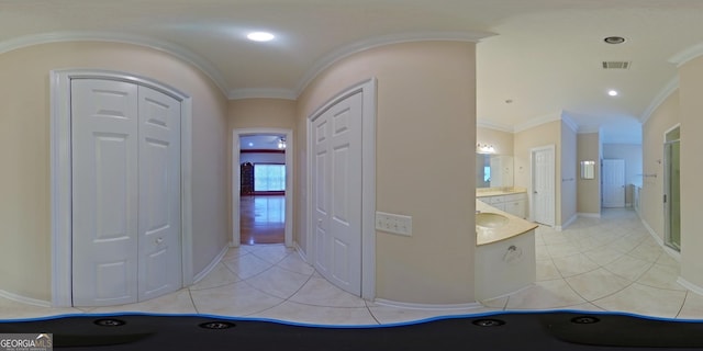 entryway featuring crown molding and light tile flooring