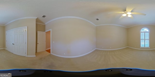 unfurnished room featuring light carpet, ornamental molding, ceiling fan, and lofted ceiling