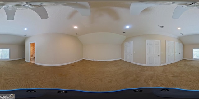 empty room with ceiling fan, light carpet, and vaulted ceiling