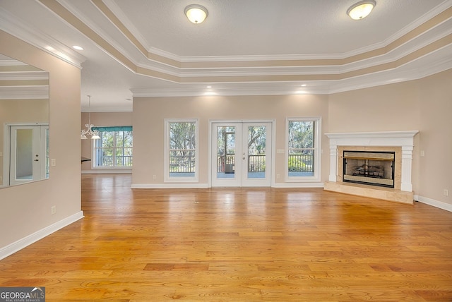 unfurnished living room featuring crown molding, light hardwood / wood-style floors, and a wealth of natural light