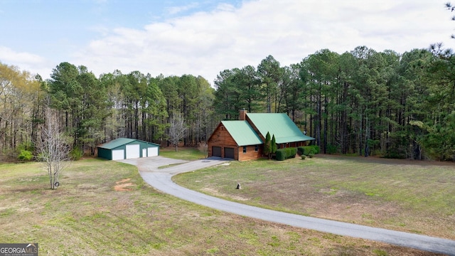 view of front of house with a front yard, a garage, and an outdoor structure