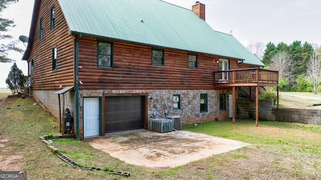 back of property featuring a wooden deck, central AC, a patio area, a garage, and a lawn