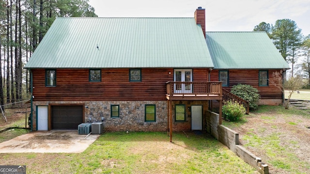 back of property featuring central air condition unit, a yard, and a garage