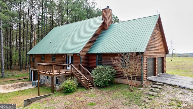 view of front of property with a wooden deck, central air condition unit, and a garage