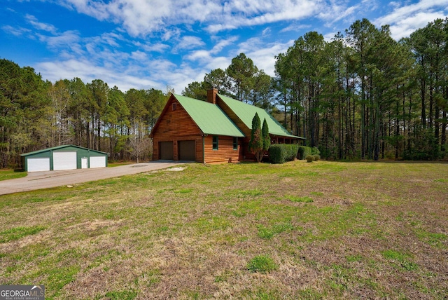 view of front of property with a front yard, an outdoor structure, and a garage