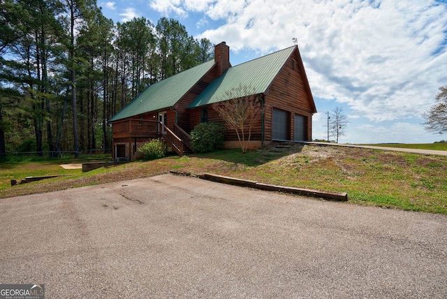 view of front of property with a deck, a front lawn, and a garage