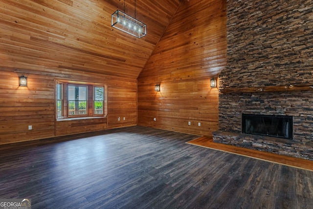 unfurnished living room featuring dark hardwood / wood-style floors, wooden ceiling, a fireplace, and wood walls