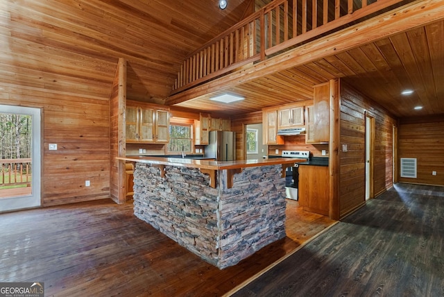 kitchen with stainless steel refrigerator, dark hardwood / wood-style flooring, and wood walls