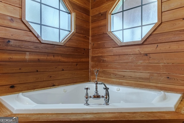 bathroom with wooden walls and a tub