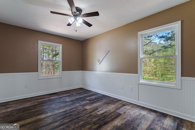 unfurnished room with dark hardwood / wood-style floors, a textured ceiling, and ceiling fan