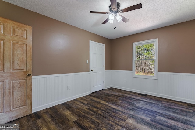 spare room with ceiling fan, dark wood-type flooring, and a textured ceiling