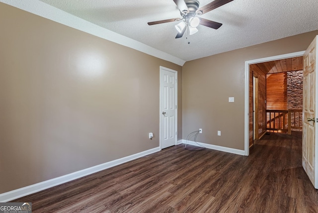 unfurnished room with ceiling fan, a textured ceiling, and dark wood-type flooring