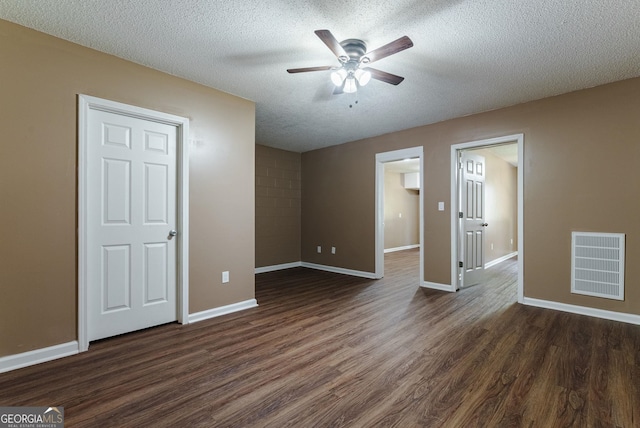 spare room with ceiling fan, a textured ceiling, and dark hardwood / wood-style flooring