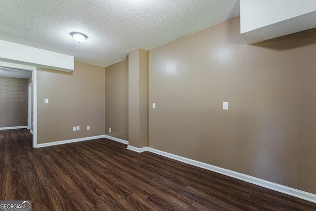 empty room with a textured ceiling and dark hardwood / wood-style floors