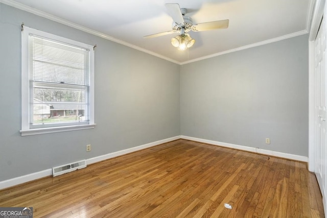 spare room with ornamental molding, light hardwood / wood-style floors, and ceiling fan