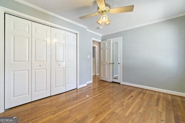 unfurnished bedroom featuring a closet, ornamental molding, ceiling fan, and light wood-type flooring