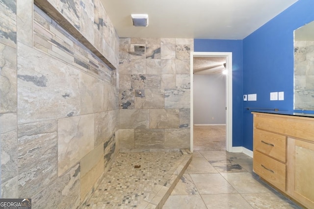 bathroom featuring a tile shower, tile floors, and large vanity