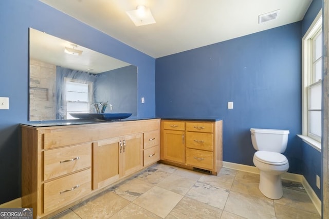 bathroom with vanity, tile floors, and toilet