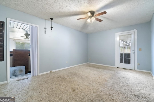 carpeted spare room with a textured ceiling and ceiling fan