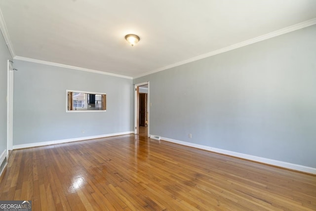 spare room featuring hardwood / wood-style floors and ornamental molding