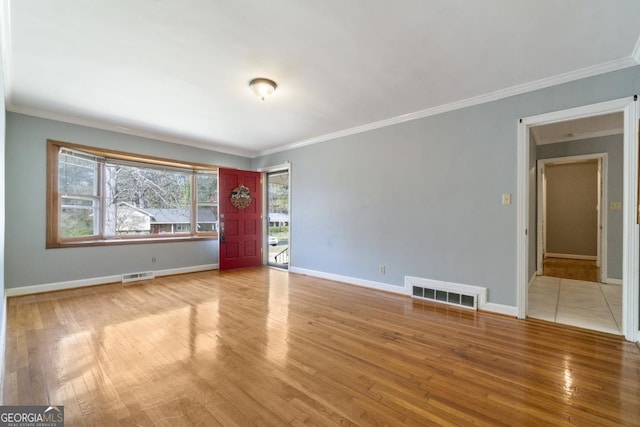 unfurnished room with crown molding and light wood-type flooring