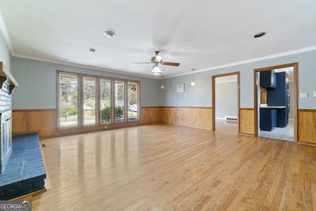 unfurnished living room with light tile flooring, ornamental molding, a brick fireplace, and ceiling fan