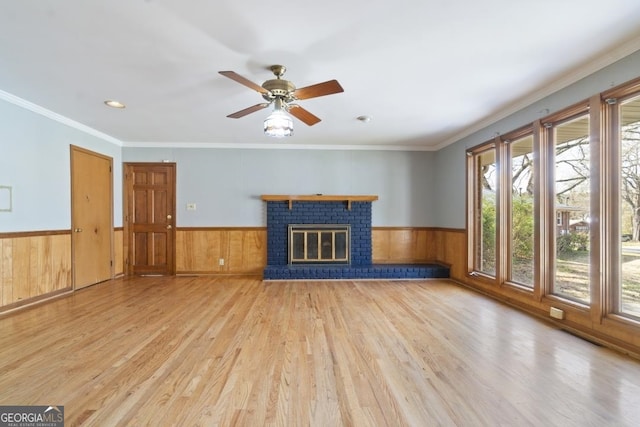 unfurnished living room with ceiling fan, a brick fireplace, and light hardwood / wood-style flooring