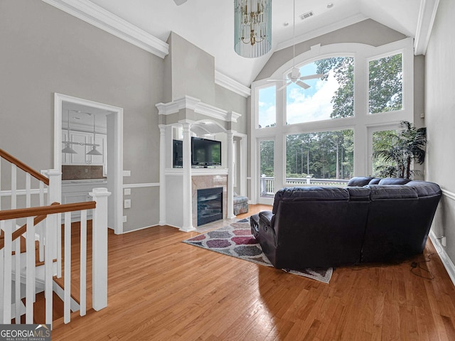 living room featuring ornamental molding, light hardwood / wood-style flooring, high vaulted ceiling, and a wealth of natural light