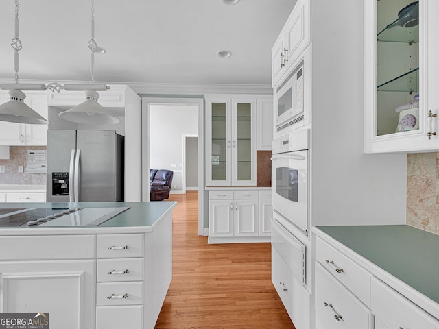 kitchen featuring white appliances, pendant lighting, tasteful backsplash, white cabinetry, and light wood-type flooring