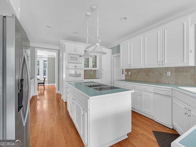 kitchen with white cabinets, a kitchen island, white appliances, and tasteful backsplash