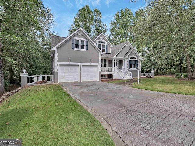 view of property featuring a front lawn, covered porch, and a garage