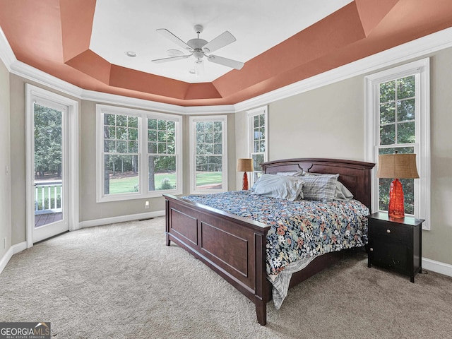 carpeted bedroom with ceiling fan, multiple windows, access to outside, and a raised ceiling