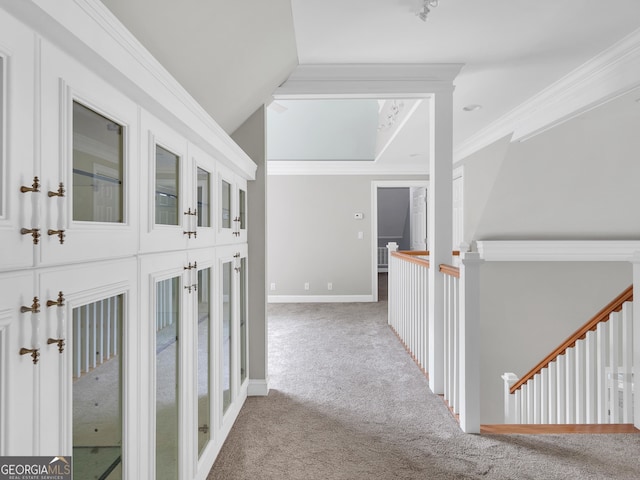 hallway featuring light carpet, ornamental molding, and lofted ceiling