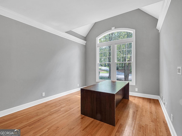 unfurnished office with ornamental molding, vaulted ceiling, and light wood-type flooring