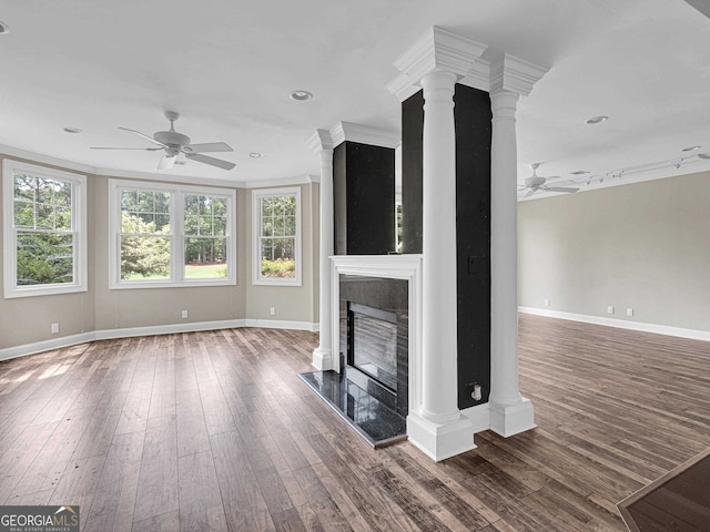 unfurnished living room with dark hardwood / wood-style flooring, decorative columns, and ceiling fan