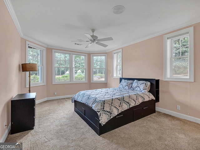 bedroom with ceiling fan, ornamental molding, and light carpet