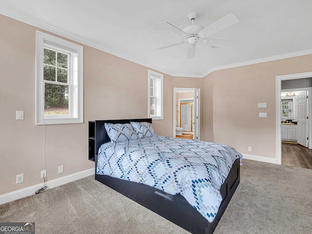 carpeted bedroom with ceiling fan, ensuite bath, and ornamental molding