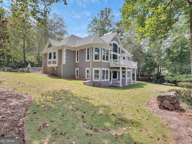 rear view of house featuring a patio and a lawn