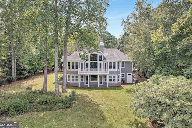 rear view of property featuring a lawn