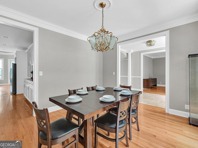 dining room featuring crown molding, a notable chandelier, and light tile flooring