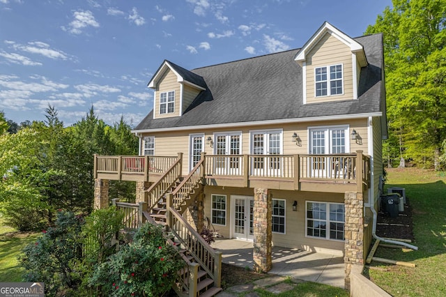 rear view of property with a deck, french doors, and a patio