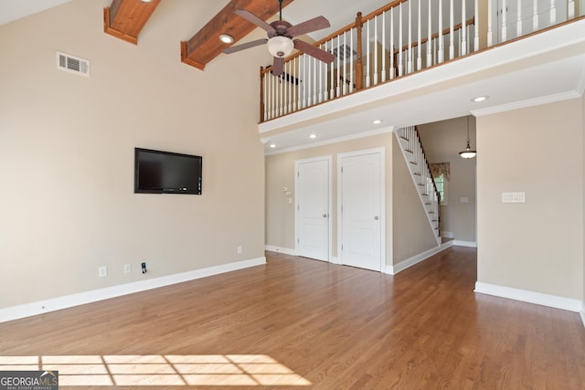 unfurnished living room with dark hardwood / wood-style flooring, ceiling fan, and a high ceiling