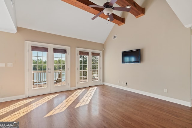 spare room with light wood-type flooring, beamed ceiling, ceiling fan, high vaulted ceiling, and french doors