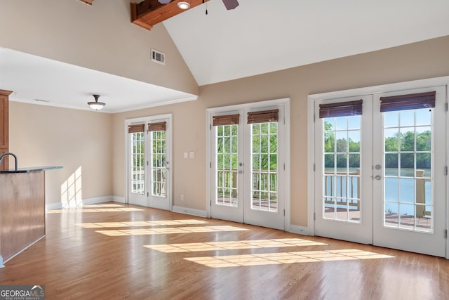 doorway to outside with beam ceiling, french doors, and light wood-type flooring